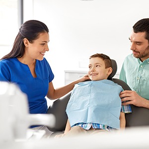 Father and son speaking with dental team member